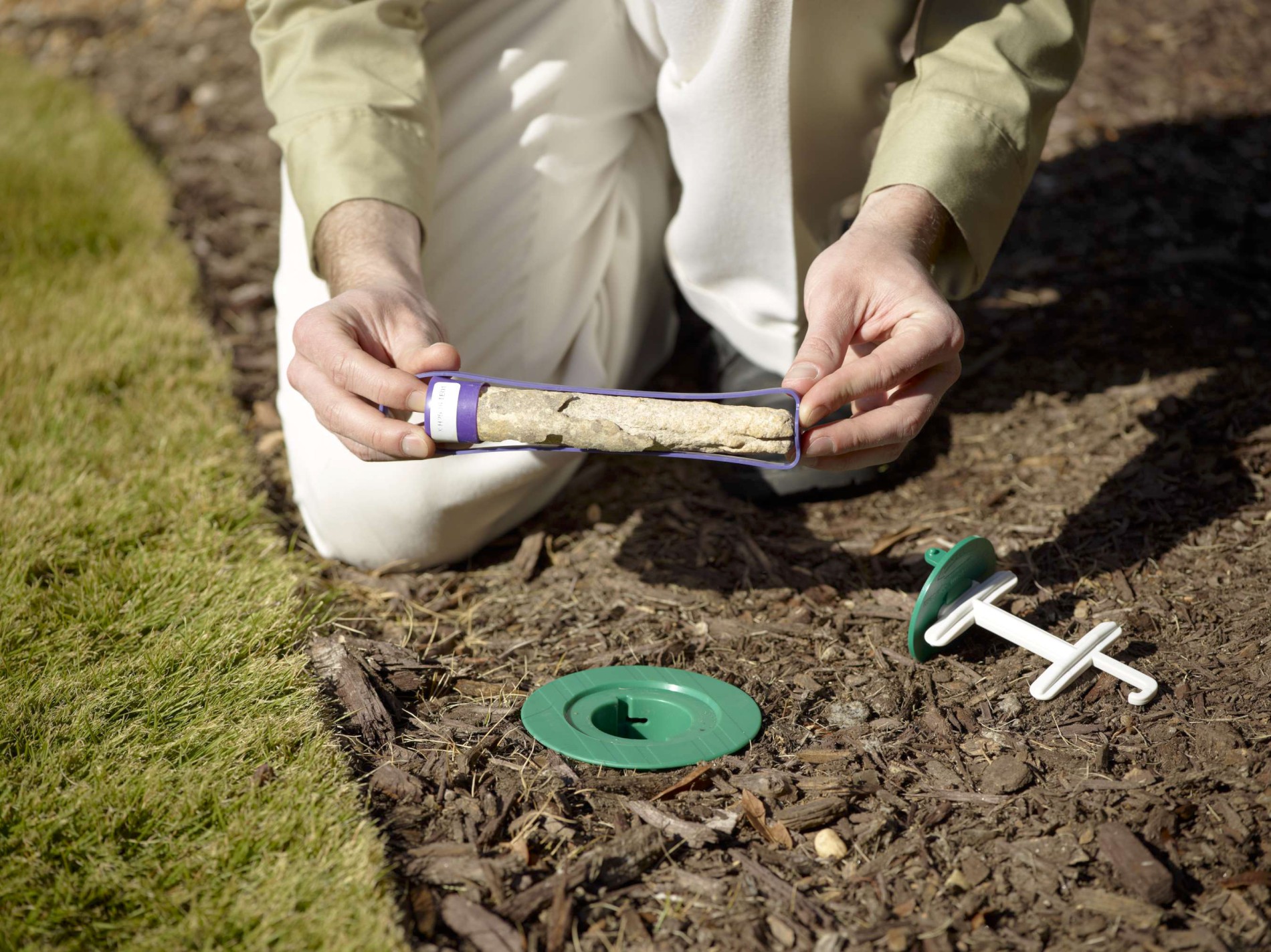 Technician inspecting Sentricon termite bait station