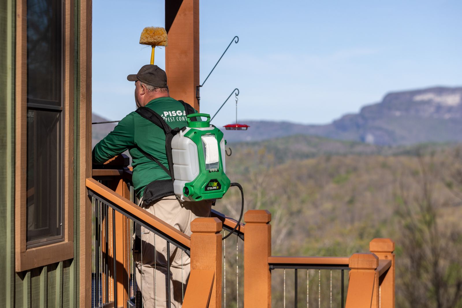 Pisgah Pest Control technician treating a mountain home deck near Cashiers, NC